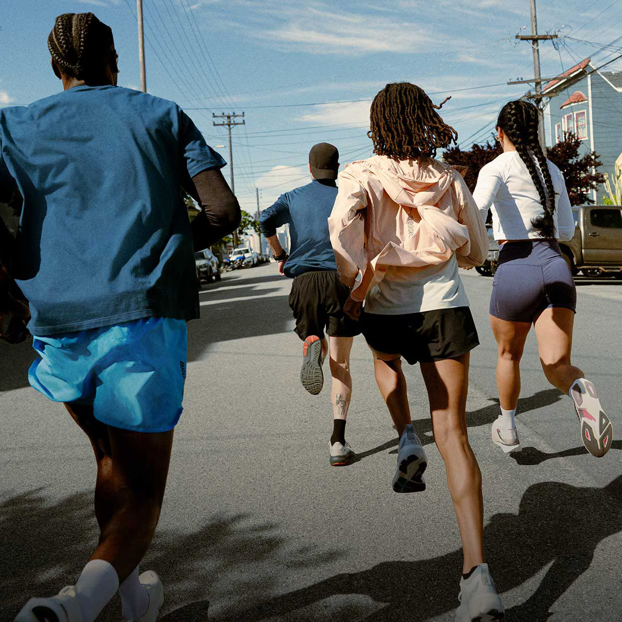 A group of people running outside on a sunny day