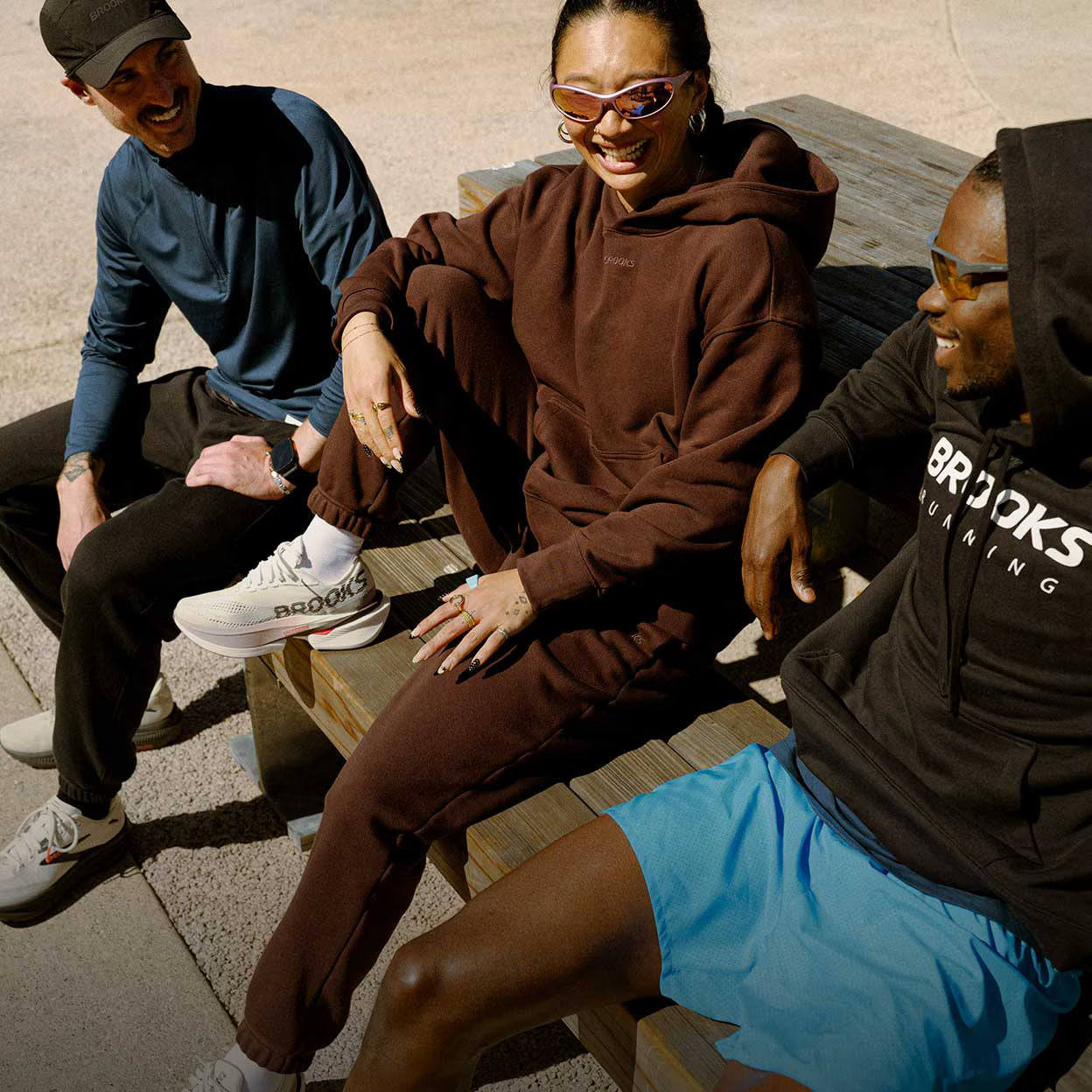 A group of people sitting outside and smiling in comfortable gear